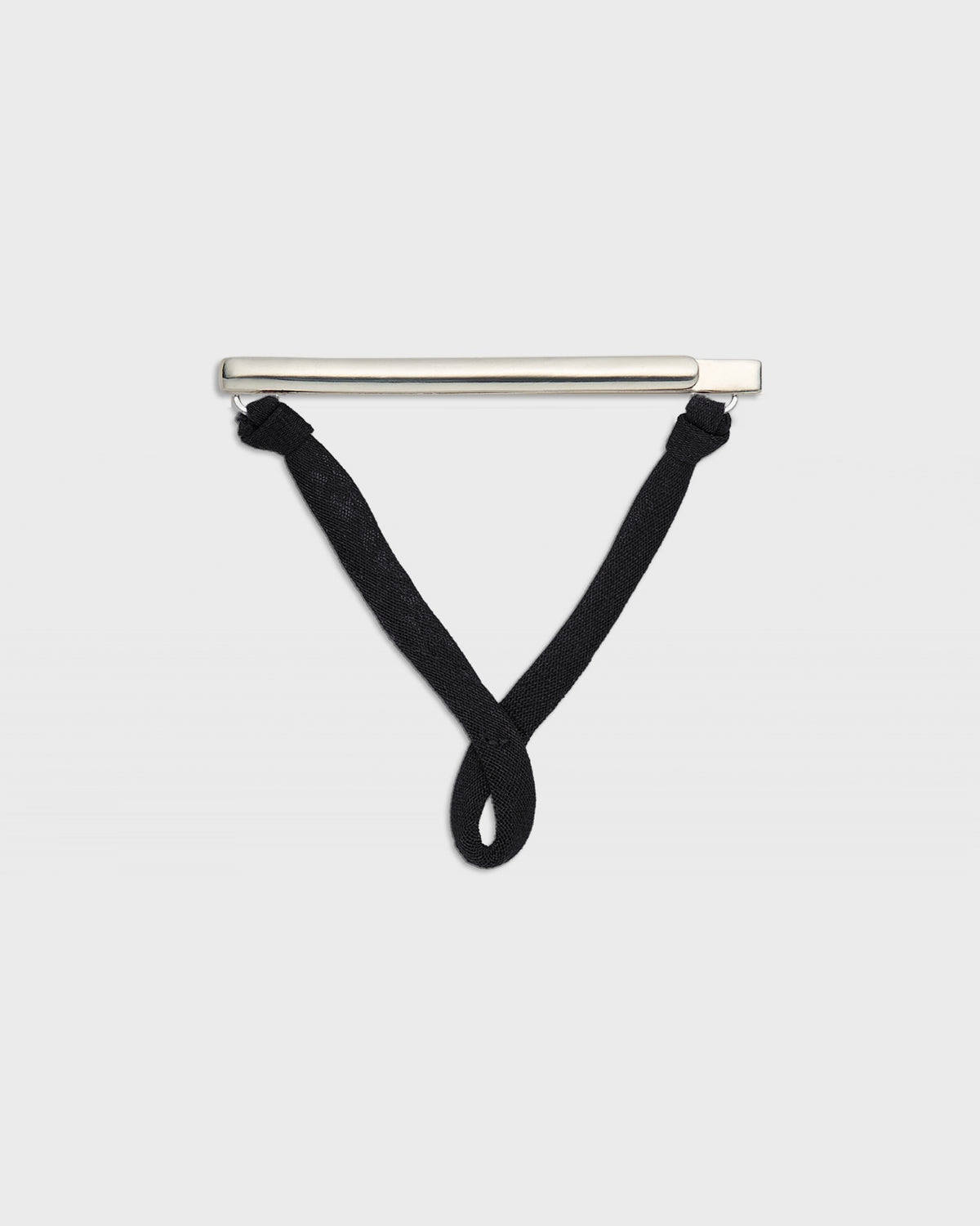 A minimalist silver bar pendant with black knotted cords hanging from its ends, displayed against a solid light gray background.