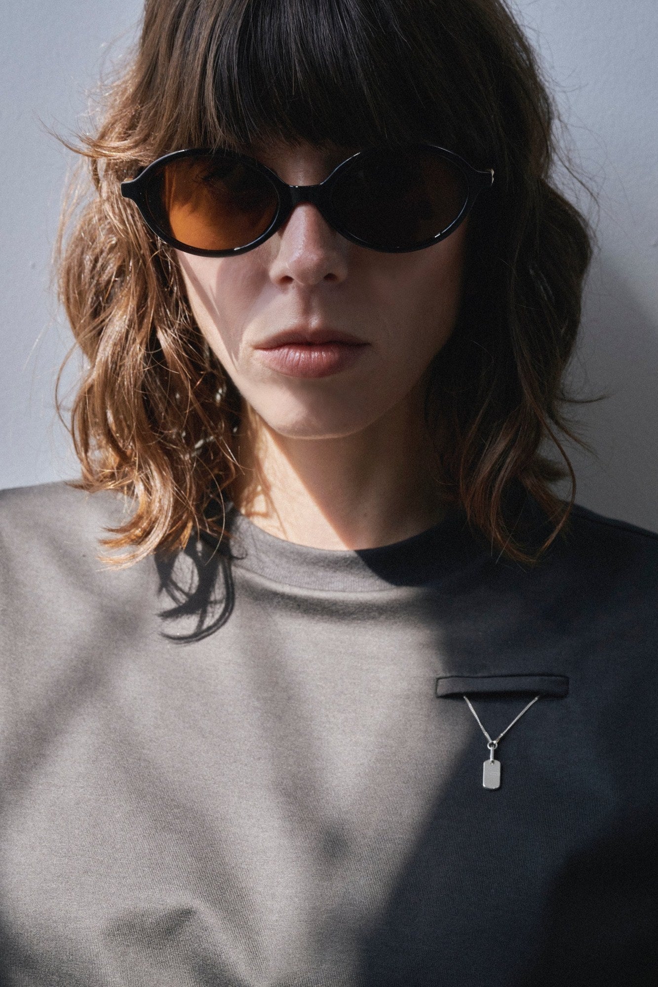 Model wearing the Aléo Studio attachment and pendant on a crewneck
