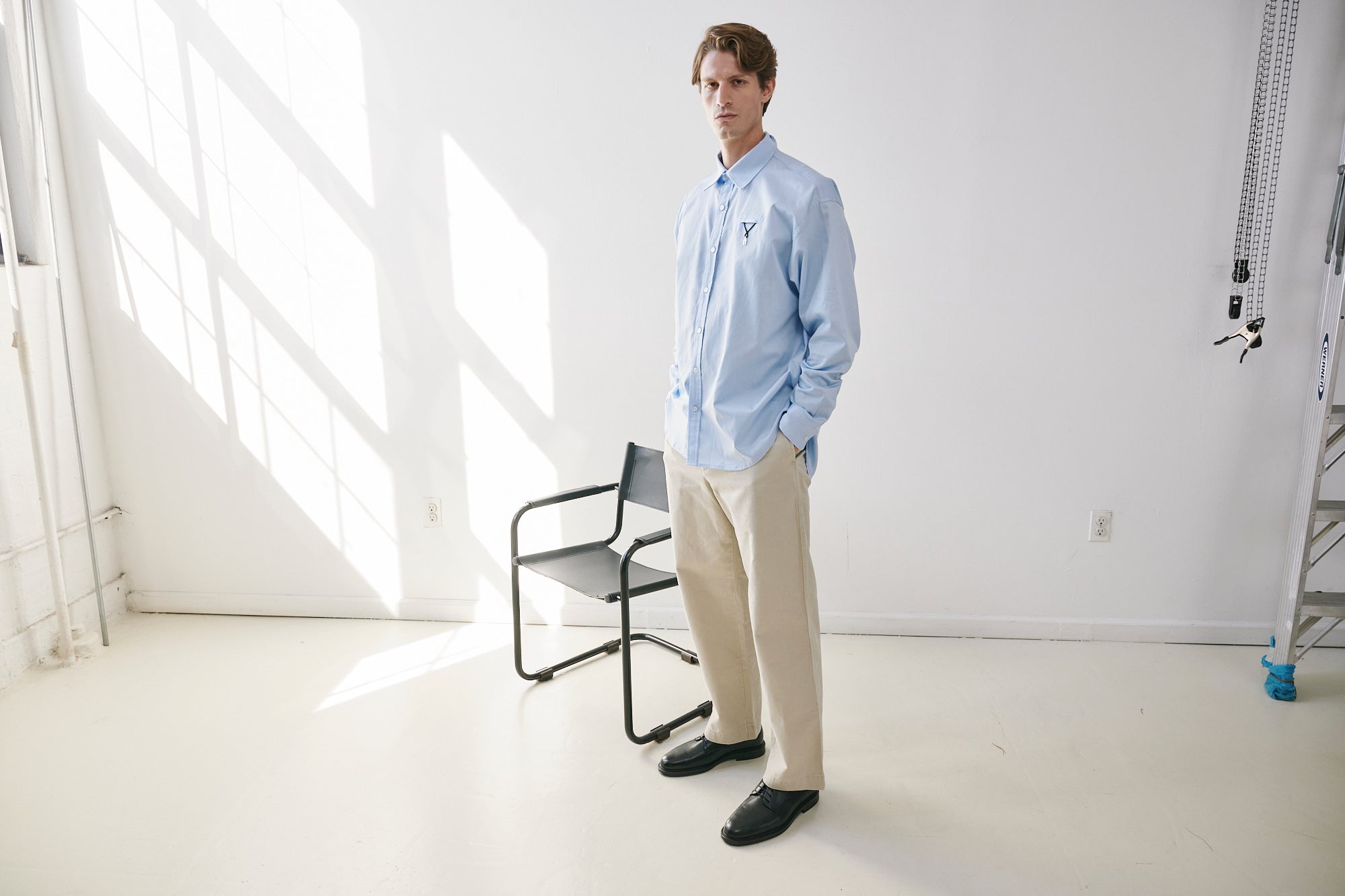 Model wearing an Aléo Studio pocket shirt in a sunlit studio